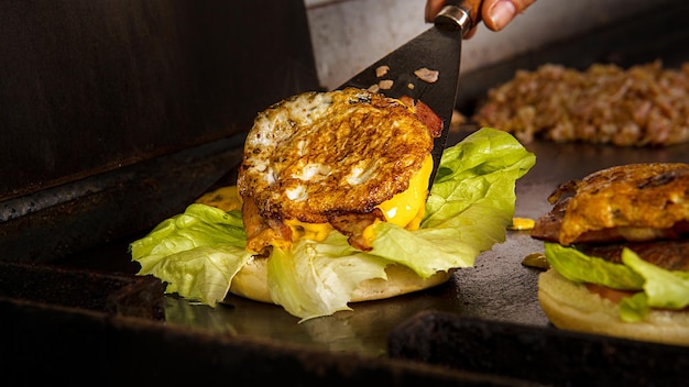 Close-up of various plant-based burgers on a grill, showcasing different textures and ingredients such as lentils, black beans, and quinoa, with grill marks and steam rising for visual appeal.