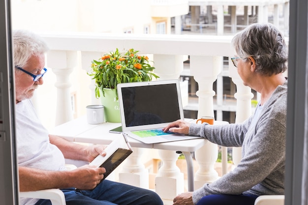 A family assisting their elderly relative in setting up a telehealth appointment on a laptop. The scene shows a warm and supportive environment, with all family members engaged and smiling, emphasizing the importance of digital literacy and family support.