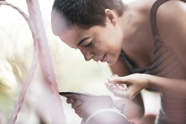 A person using a mental wellness app on their phone. The app features an AI chatbot interface where the user is typing a message expressing their feelings. The background shows a calming outdoor scene.