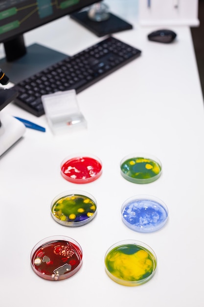 A close-up of a lab technician analyzing a DNA microarray, with colorful spots indicating different genetic markers. The background shows other lab equipment and personnel working on various tests.