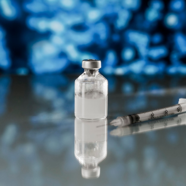 A close-up of a vaccine vial and syringe, with a blurred background of healthcare professionals. The image should focus on the scientific aspect of vaccines and their role in preventing disease.