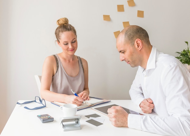 A person talking to an insurance agent, reviewing documents and discussing the details of different health insurance plans.