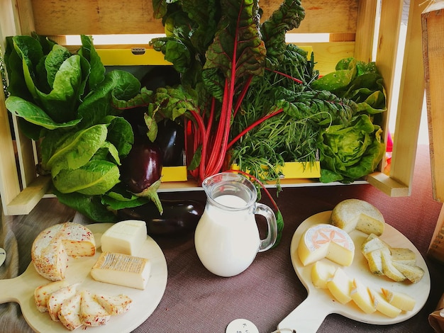 A diverse selection of calcium-rich foods, including dairy products, leafy green vegetables, and fortified plant-based milk alternatives, displayed on a wooden table.