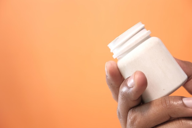 A person's hands holding a bottle of glucosamine and chondroitin supplements. In the background, there's a doctor writing on a notepad during a consultation, suggesting a discussion about joint health.