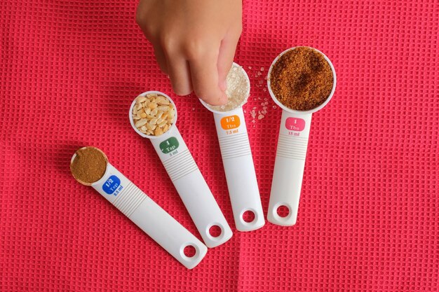 An image showing various measuring cups and spoons alongside a nutrition label, with a hand pouring cereal into a measuring cup to illustrate proper portion control. The focus is on the tools and techniques for measuring serving sizes accurately.