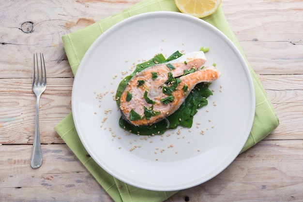A close-up shot of a plate featuring grilled salmon with a side of steamed spinach and a sprinkle of almonds. The focus is on the vibrant colors and textures of the fresh ingredients, highlighting their nutritional benefits.
