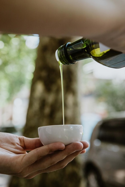 A close-up shot of a bottle of extra virgin olive oil being poured over a fresh salad with mixed greens, tomatoes, and cucumbers. The focus is on the golden color of the olive oil and the vibrancy of the vegetables, emphasizing the health benefits of the Mediterranean diet.
