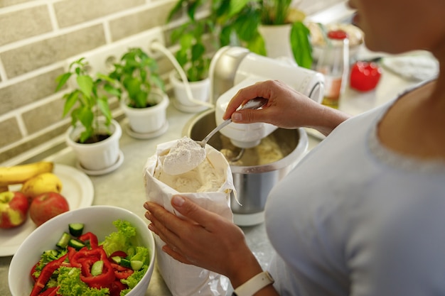 A person preparing a vibrant plant-based meal in a sunlit kitchen, with a focus on ingredients like tofu, colorful vegetables, and whole grains. The image highlights the freshness and appeal of plant-based cuisine.