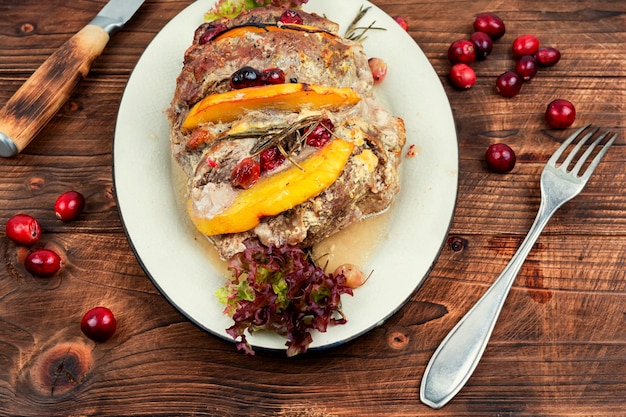 A beautifully plated dish of baked salmon with colorful roasted vegetables, including bell peppers, zucchini, and cherry tomatoes, drizzled with olive oil and garnished with fresh herbs.