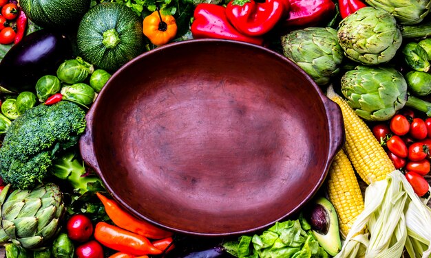 A colorful vegetable stir-fry in a pan, with a variety of vegetables such as broccoli, carrots, bell peppers and onions, being cooked over a stove. The pan is steaming slightly, and there are cooking utensils visible around it.