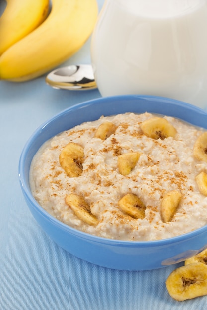 A close-up shot of a bowl of freshly prepared oatmeal topped with sliced bananas, a sprinkle of chia seeds, and a drizzle of honey. The oatmeal has a creamy texture, and steam is gently rising from the bowl.
