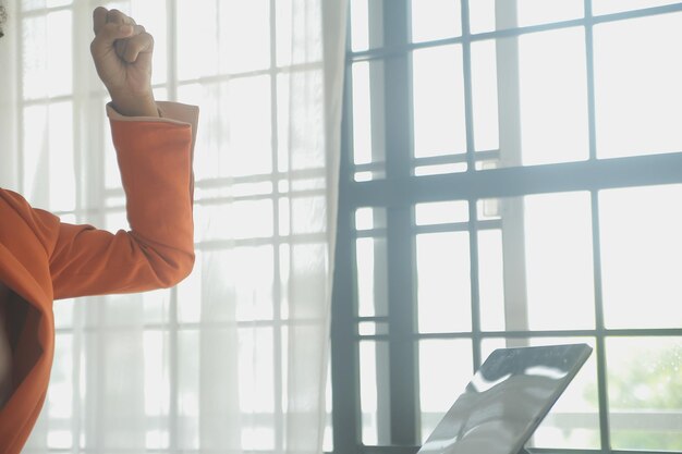 A sunlight-filled office, with a person sitting near a window and holding their arm out to soak in the sunlight. The atmosphere is calm and promotes the benefits of sunlight in boosting vitamin D and overall wellness.
