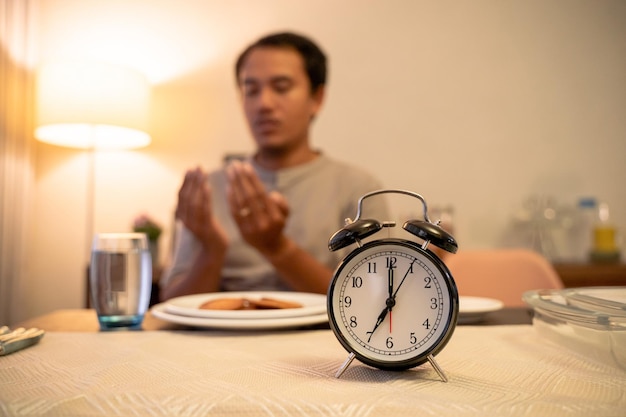 A person setting an alarm clock for a consistent wake-up time, with a calendar in the background showing a consistent sleep schedule, emphasizing the importance of routine.